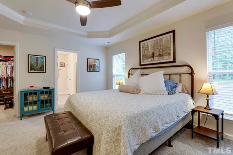 a bedroom with a bed wooden floor and window