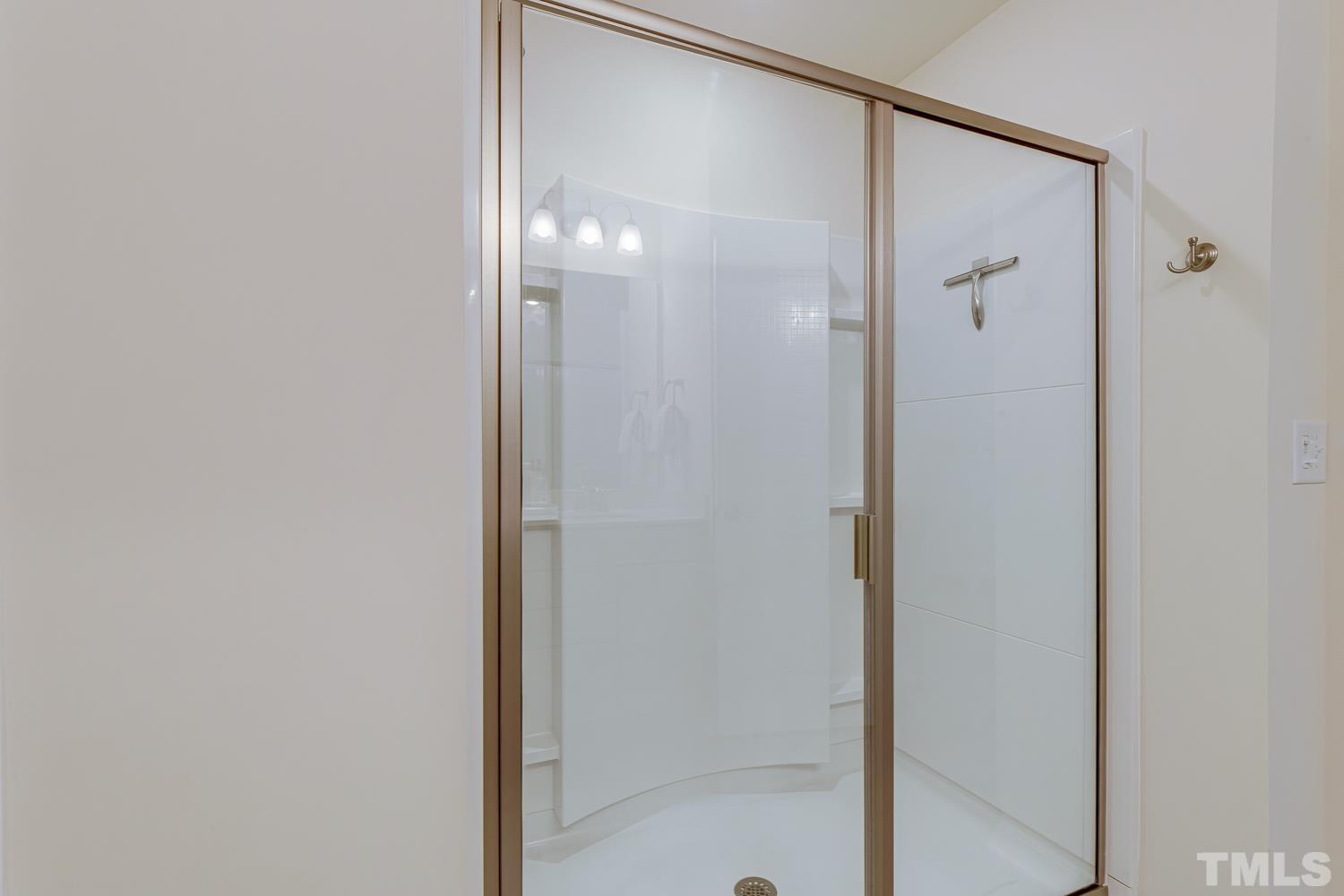 3155 Retama Run New Hill, NC 27562 - Photo 30 of 48 a bathroom with a glass shower door