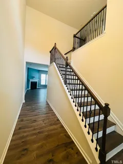 a view of staircase with wooden floor and white walls