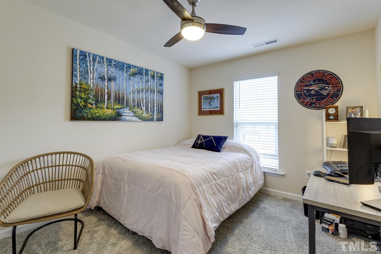 3155 Retama Run New Hill, NC 27562 - Photo 35 of 48 a bedroom with a bed and a chandelier