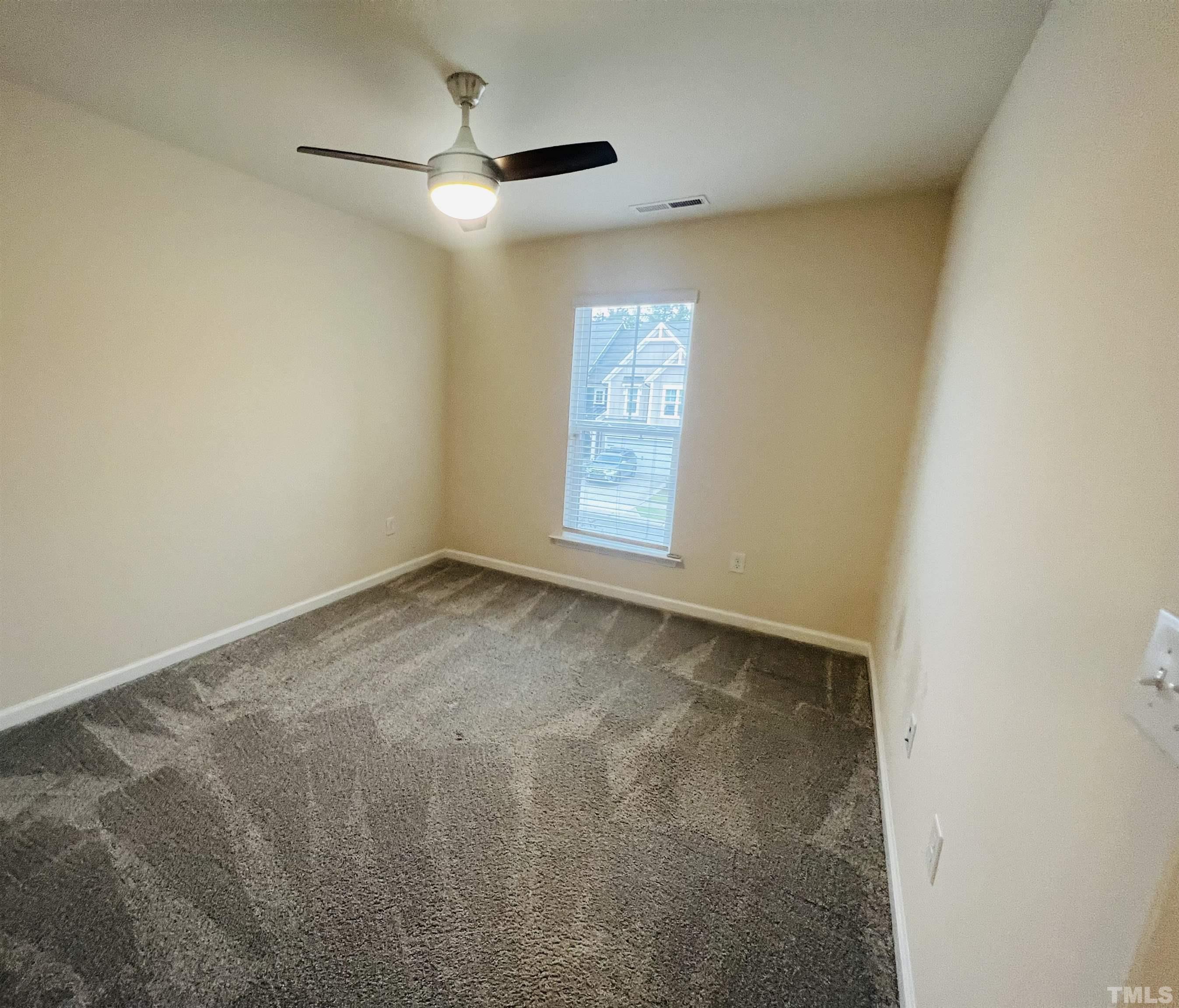 3155 Retama Run New Hill, NC 27562 - Photo 36 of 48 an empty room with a window and a fan