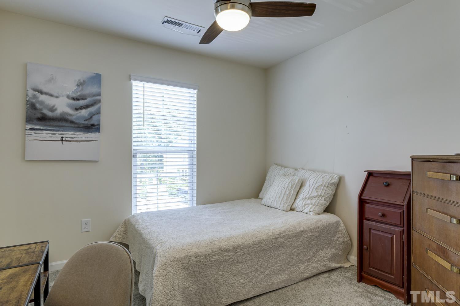 3155 Retama Run New Hill, NC 27562 - Photo 38 of 48 a bedroom with a bed and a painting on the wall