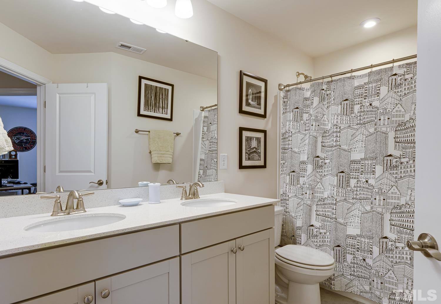 3155 Retama Run New Hill, NC 27562 - Photo 39 of 48 a bathroom with a toilet sink and mirror