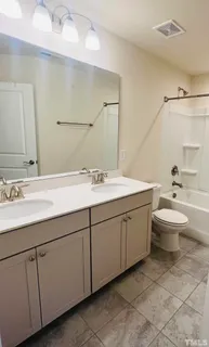 a bathroom with a double vanity sink mirror and toilet
