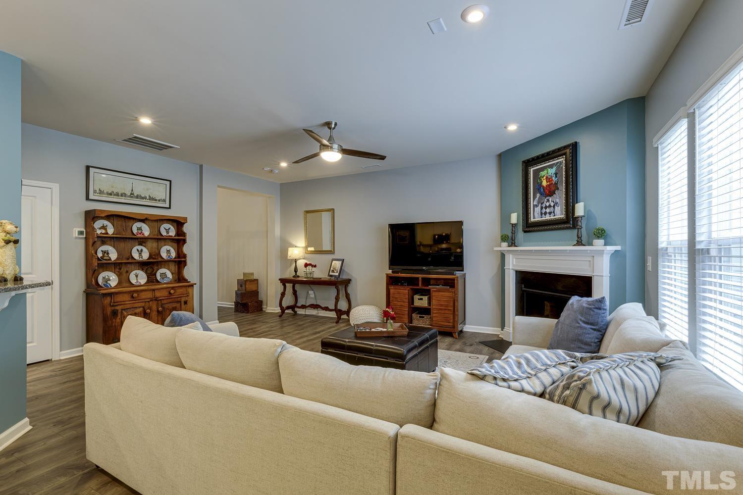 3155 Retama Run New Hill, NC 27562 - Photo 6 of 48 a living room with furniture a fireplace and a flat screen tv