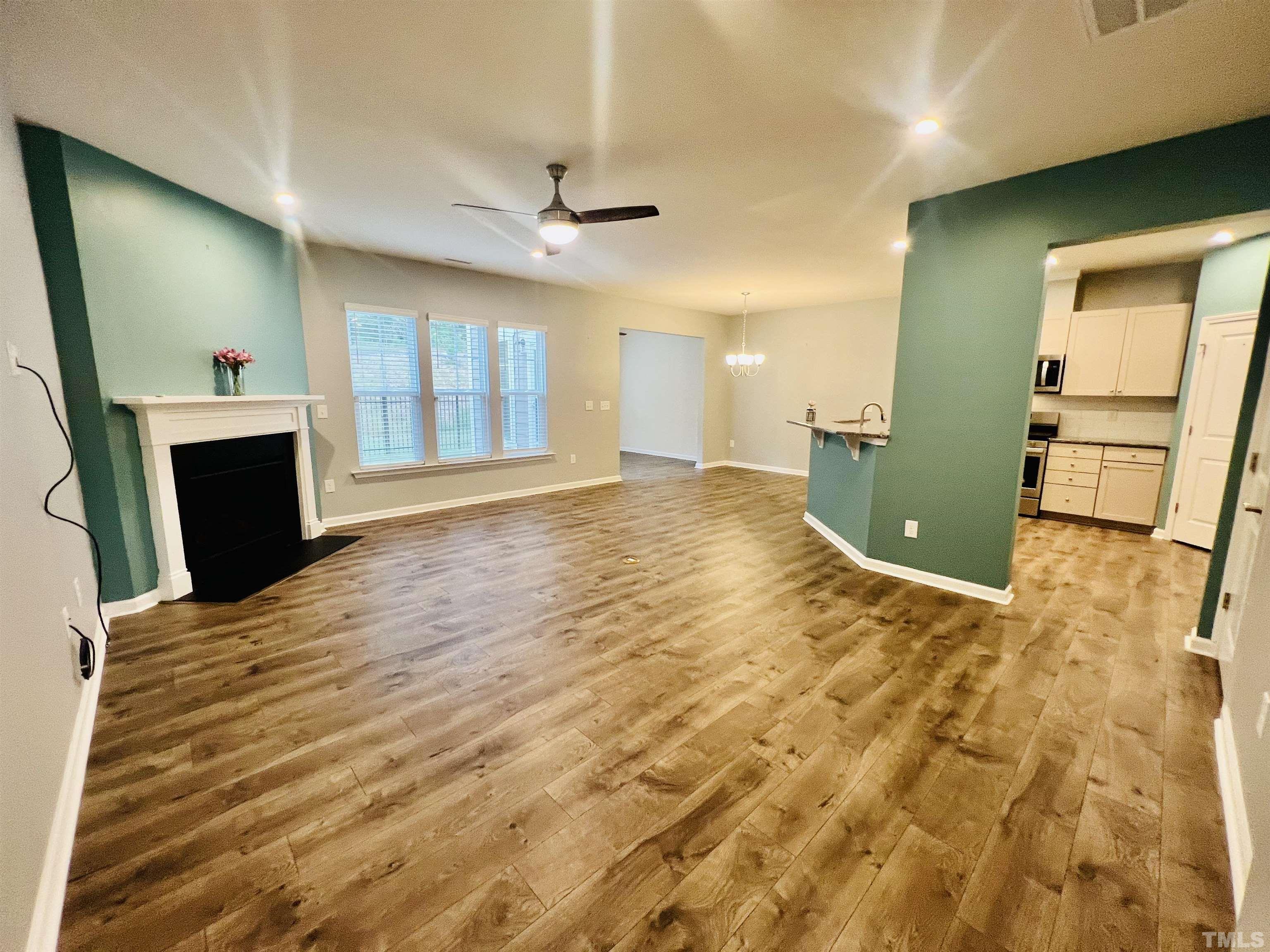3155 Retama Run New Hill, NC 27562 - Photo 10 of 48 a view of empty room with a fireplace and wooden floor