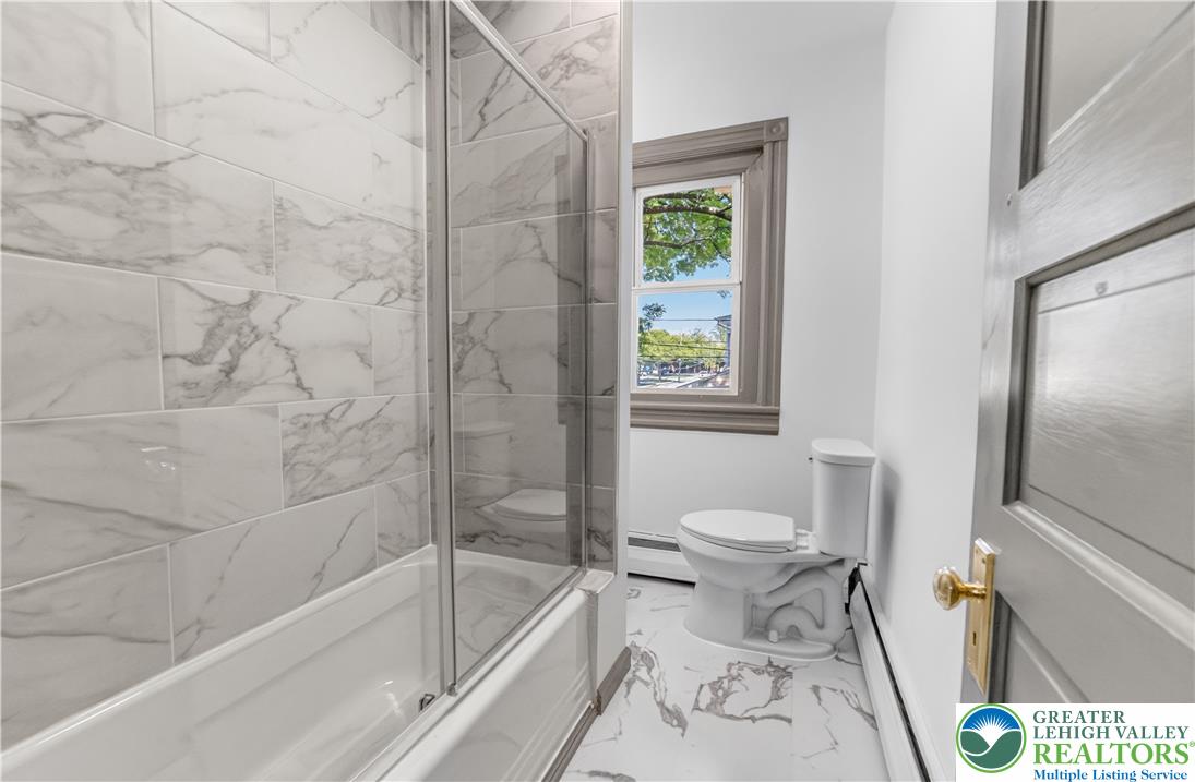 1128 Maple Street Bethlehem, PA 18018 - Photo 19 of 34 Marble-inspired tiling and a large window create an airy, luminous bathroom retreat.