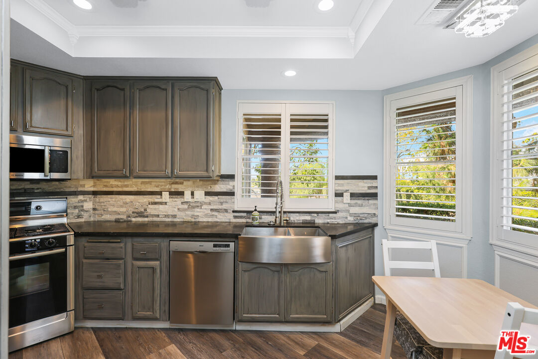 24193 Harbor Ridge Lane, Unit 81 Lake Forest, CA 92630 - Photo 1 of 43 a kitchen with stainless steel appliances granite countertop a stove a sink and a microwave