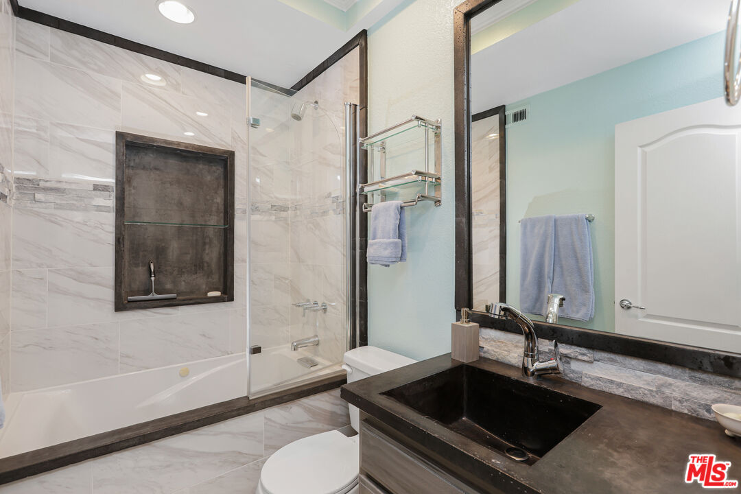 24193 Harbor Ridge Lane, Unit 81 Lake Forest, CA 92630 - Photo 19 of 43 a bathroom with a granite countertop sink a toilet a mirror and bathtub