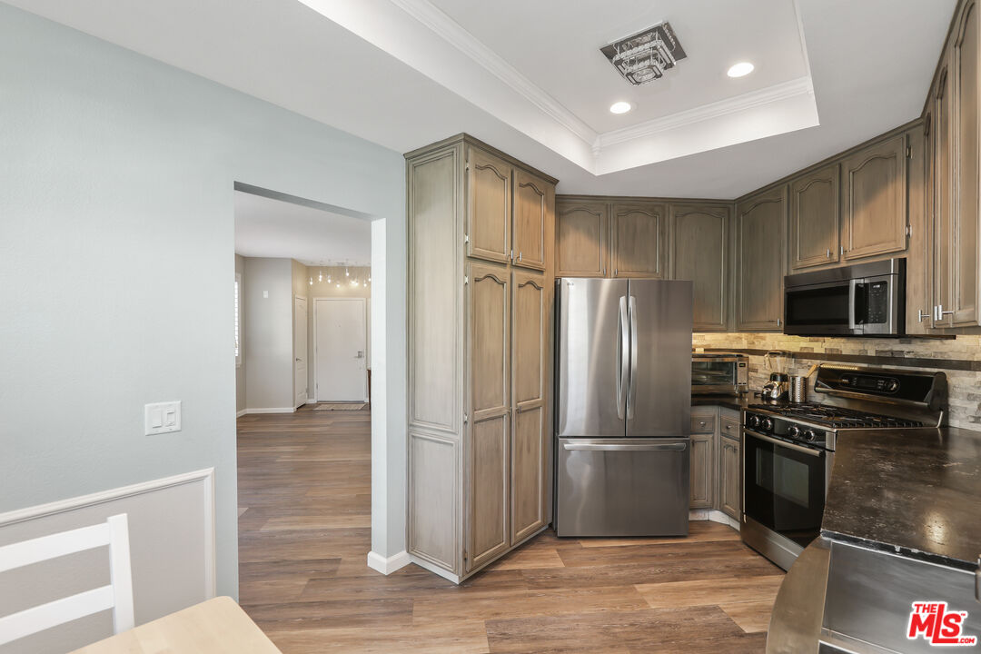 24193 Harbor Ridge Lane, Unit 81 Lake Forest, CA 92630 - Photo 7 of 43 a metallic refrigerator freezer and a stove sitting inside of a kitchen