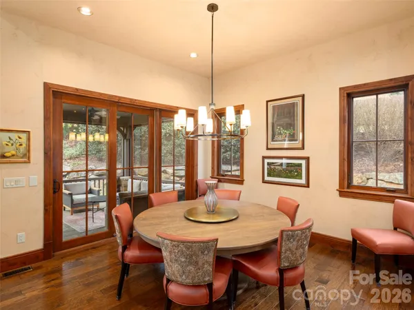 a dining room with furniture a chandelier and wooden floor