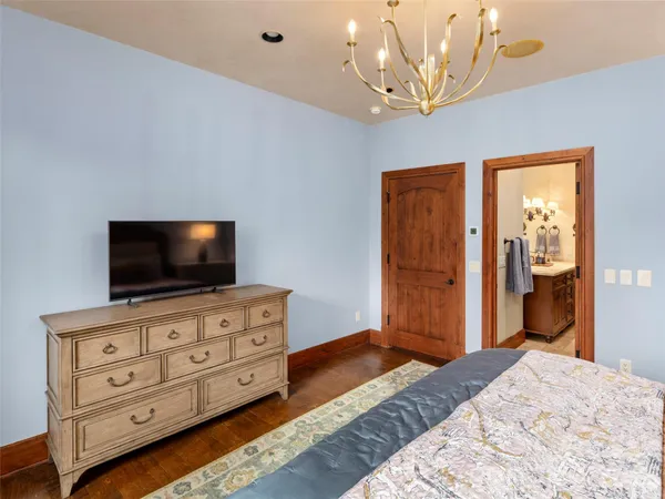 a bedroom with a bed and a flat tv screen on dresser