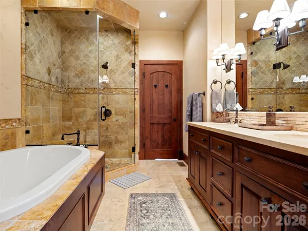a spacious bathroom with a double vanity sink a large mirror and a bathtub