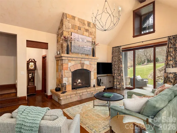 a living room with furniture a rug a fireplace and a large window