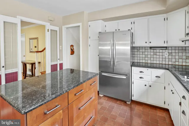 a kitchen with stainless steel appliances granite countertop a refrigerator a stove and white cabinets