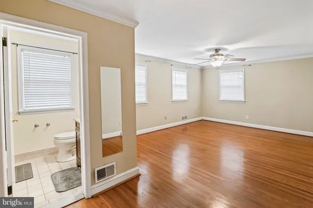a bathroom with a granite countertop sink toilet and mirror