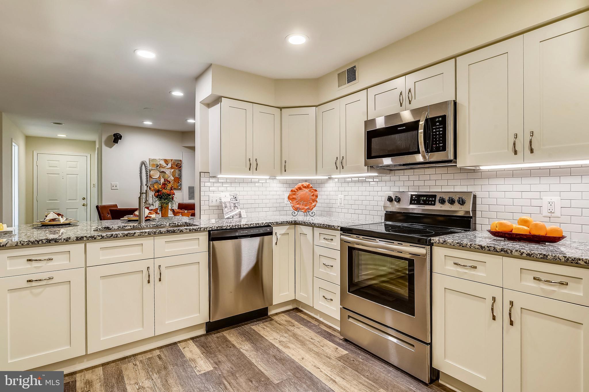 2241 Lovedale Lane, Unit B Reston, VA 20191 - Photo 11 of 27 a kitchen with white cabinets stainless steel appliances and sink