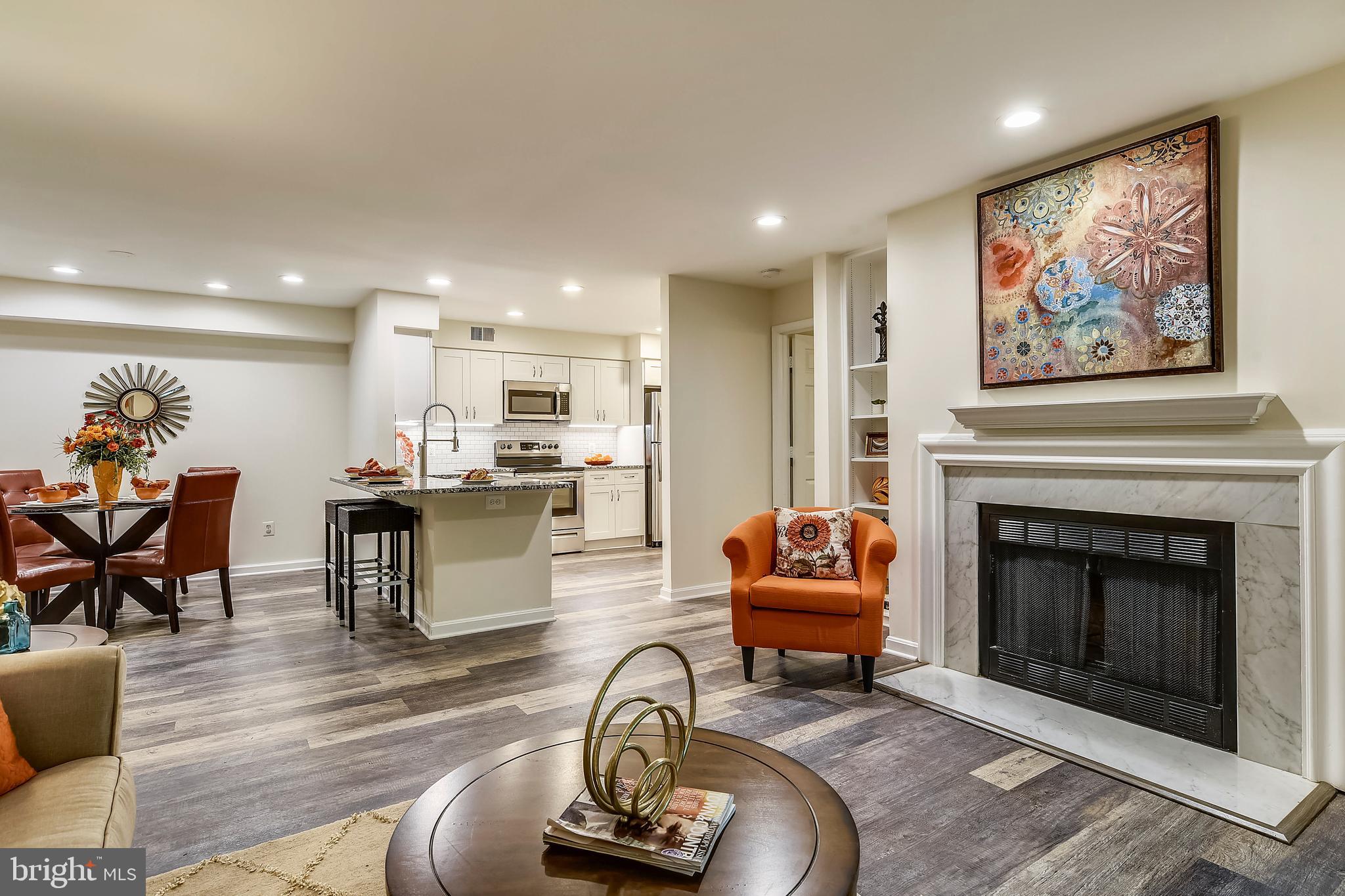 2241 Lovedale Lane, Unit B Reston, VA 20191 - Photo 14 of 27 a living room with furniture a fireplace and kitchen view