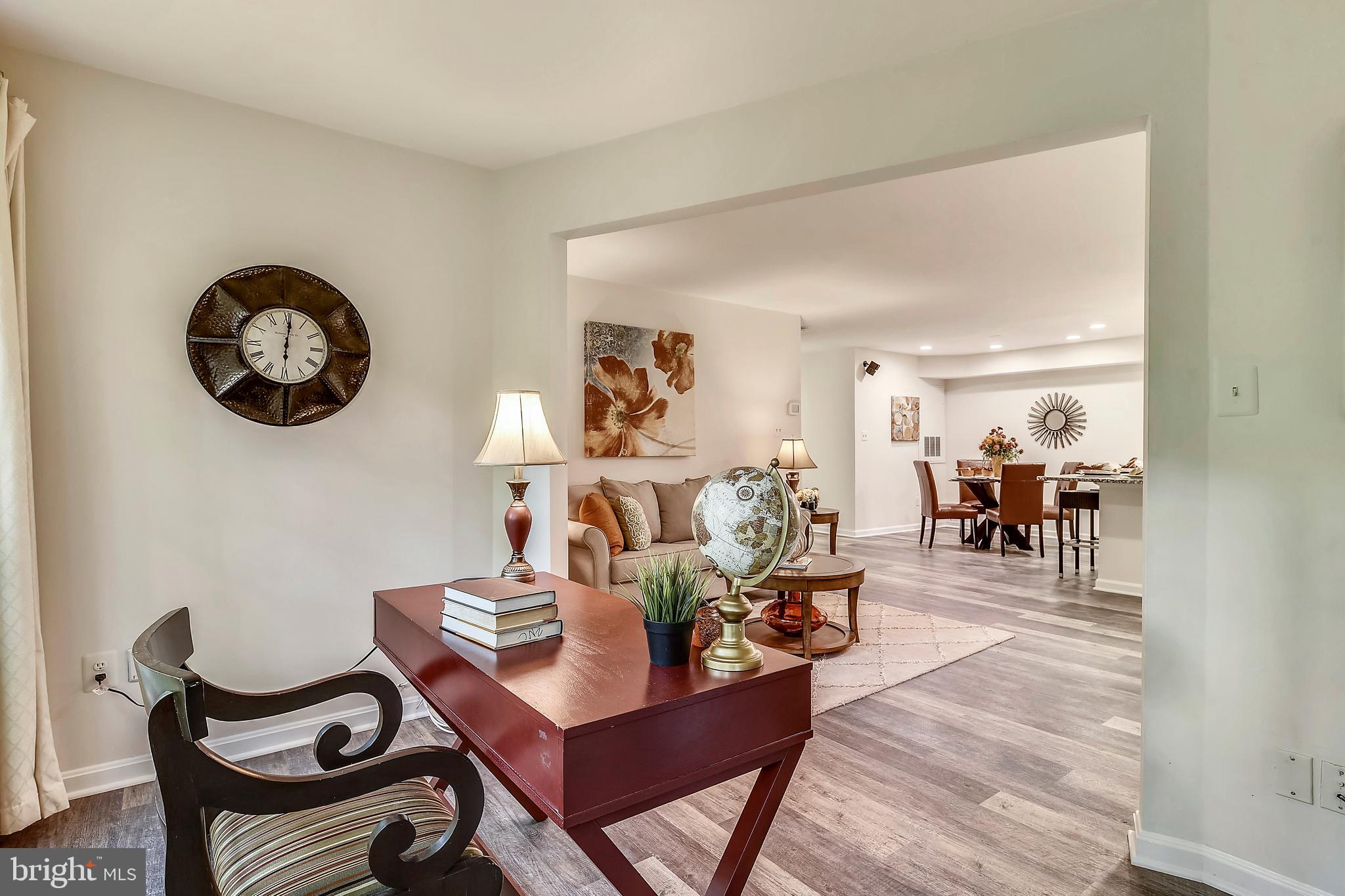2241 Lovedale Lane, Unit B Reston, VA 20191 - Photo 22 of 27 a view of a dining room and livingroom with furniture wooden floor a rug a fireplace and a large window