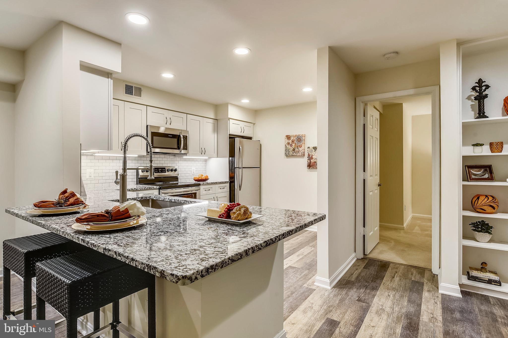 2241 Lovedale Lane, Unit B Reston, VA 20191 - Photo 10 of 27 a kitchen with sink a refrigerator and chairs