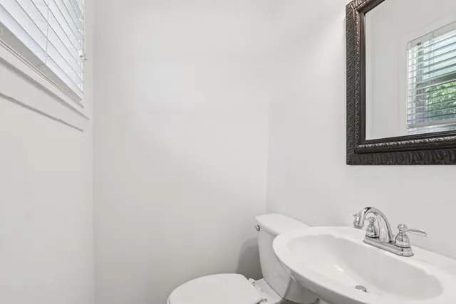 a bathroom with a toilet a sink and mirror