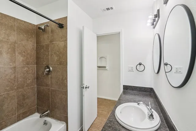 a bathroom with a granite countertop sink toilet and shower