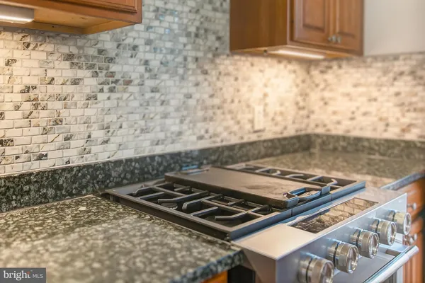 a kitchen with granite countertop a sink a counter space appliances and cabinets