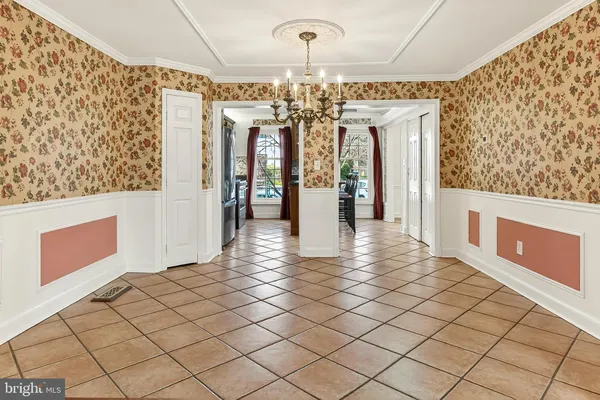 a view of a livingroom with a chandelier fan and windows