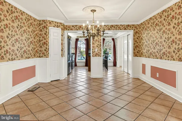 a view of a livingroom with a chandelier fan and windows