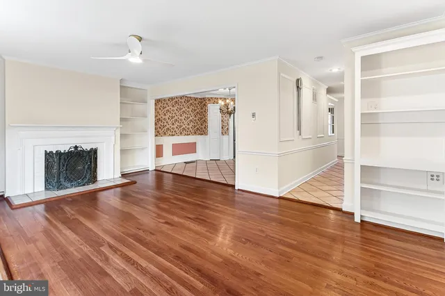 a view of a hallway with wooden floor and a bathroom