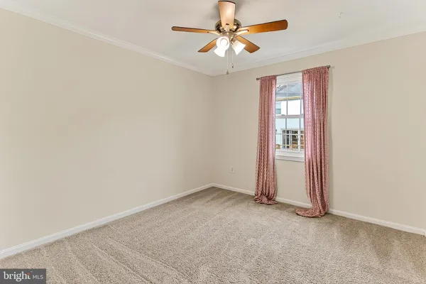 a view of an empty room with a ceiling fan