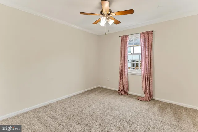 a view of an empty room with a ceiling fan