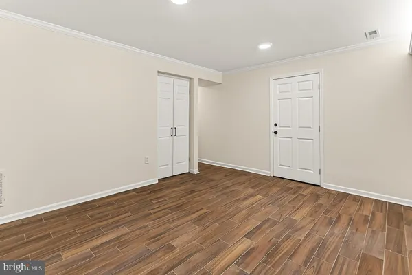 a view of an empty room with wooden floor