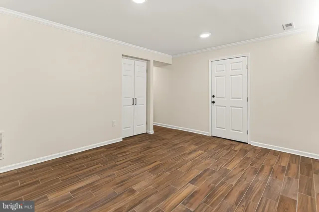 a view of an empty room with wooden floor