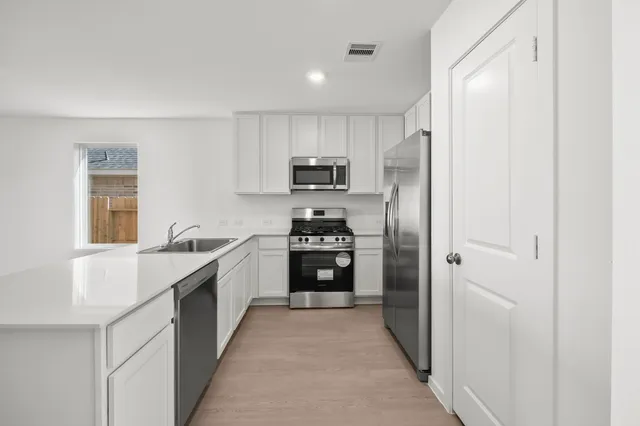 a kitchen with stainless steel appliances granite countertop a refrigerator and a stove top oven