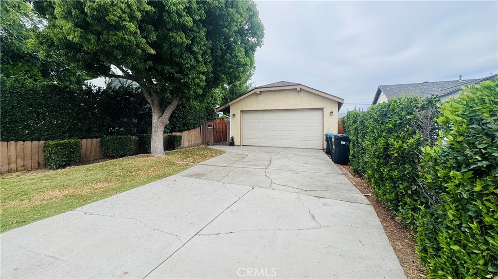a view of a house with a yard and large tree