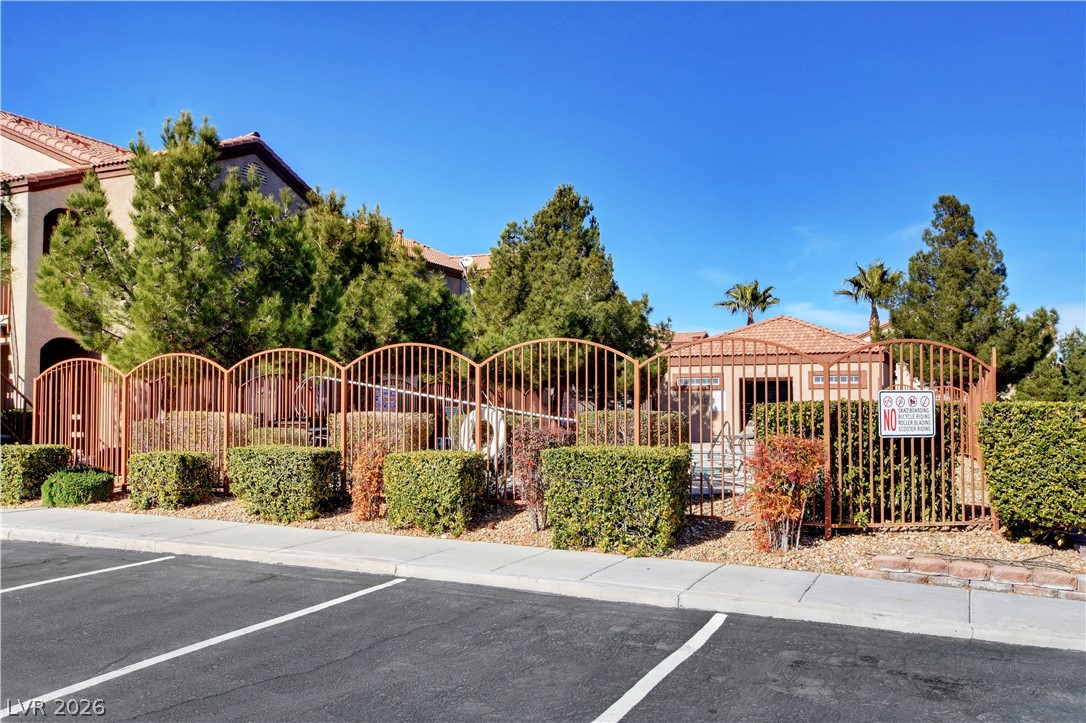 9580 West Reno Avenue, Unit 134 Las Vegas, NV 89148 - Photo 40 of 41 Secure community entrance with well-maintained landscaping and a resort-style pool building.