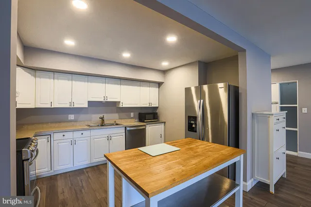 a view of a kitchen with wooden floor and electronic appliances