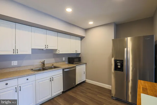 a kitchen with a refrigerator sink and cabinets