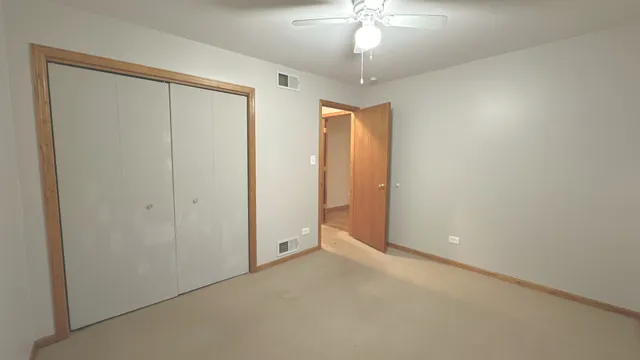 a view of an empty room with a chandelier fan
