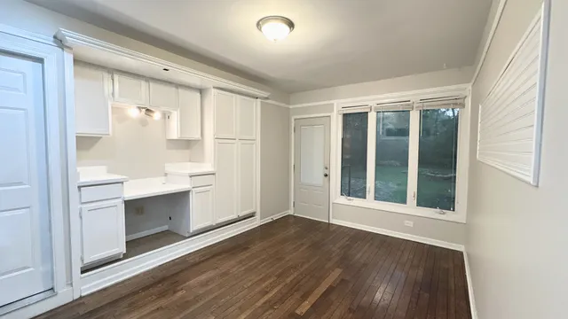 a view of an empty room with cabinet and a window
