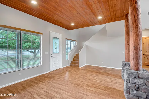 a view of a big room with wooden floor and windows
