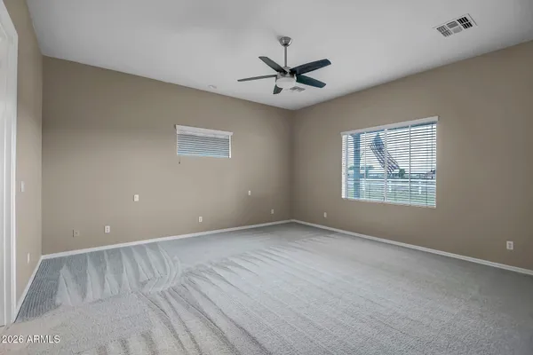 an empty room with a window and a fan