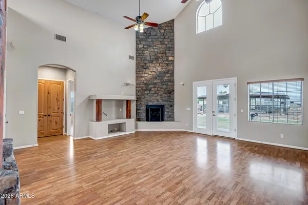 a view of empty room with wooden floor and a fireplace