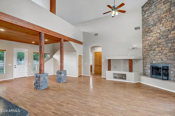 an empty room with wooden floor windows and fireplace
