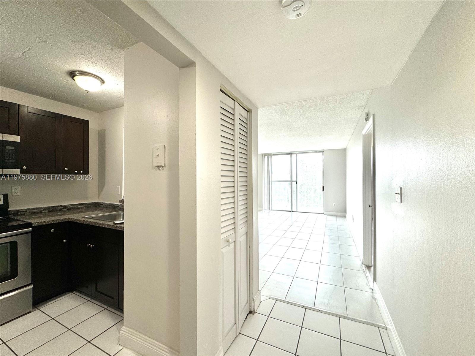 484 Northwest 165th St Road, Unit A411 Miami, FL 33169 - Photo 8 of 18 a kitchen with a sink and a refrigerator