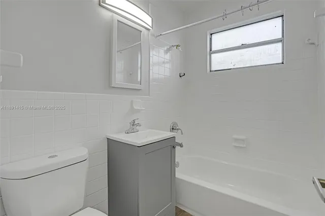 a bath room with a toilet a sink and a bath tub