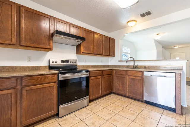 a kitchen with granite countertop a sink stainless steel appliances and cabinets
