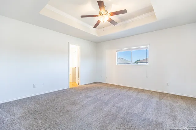 an empty room with a window and a fan