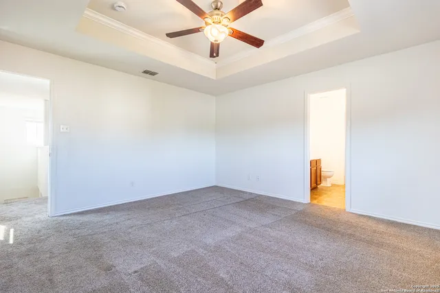 an empty room with a ceiling fan and a window